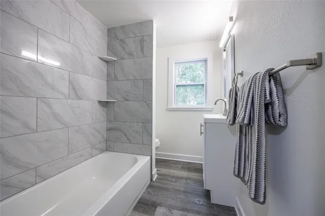 a bathroom with a tub a sink and a window