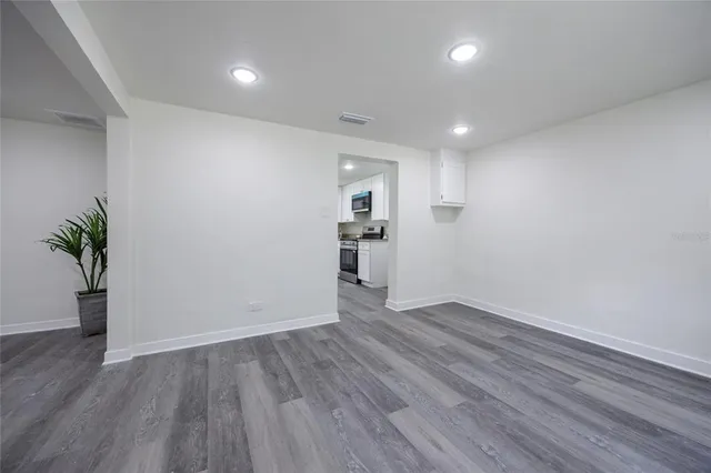 a view of empty room with wooden floor and window