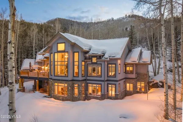 a view of a lush green forest with a house
