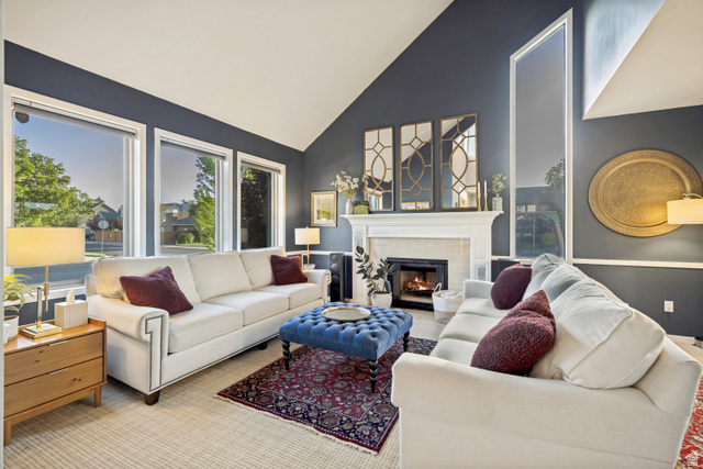 1837 Richard Road Sandy, UT 84093 - Photo 34 of 67 Living area featuring vaulted ceilings, a fireplace with a white mantel, multiple large windows, and dark accent walls