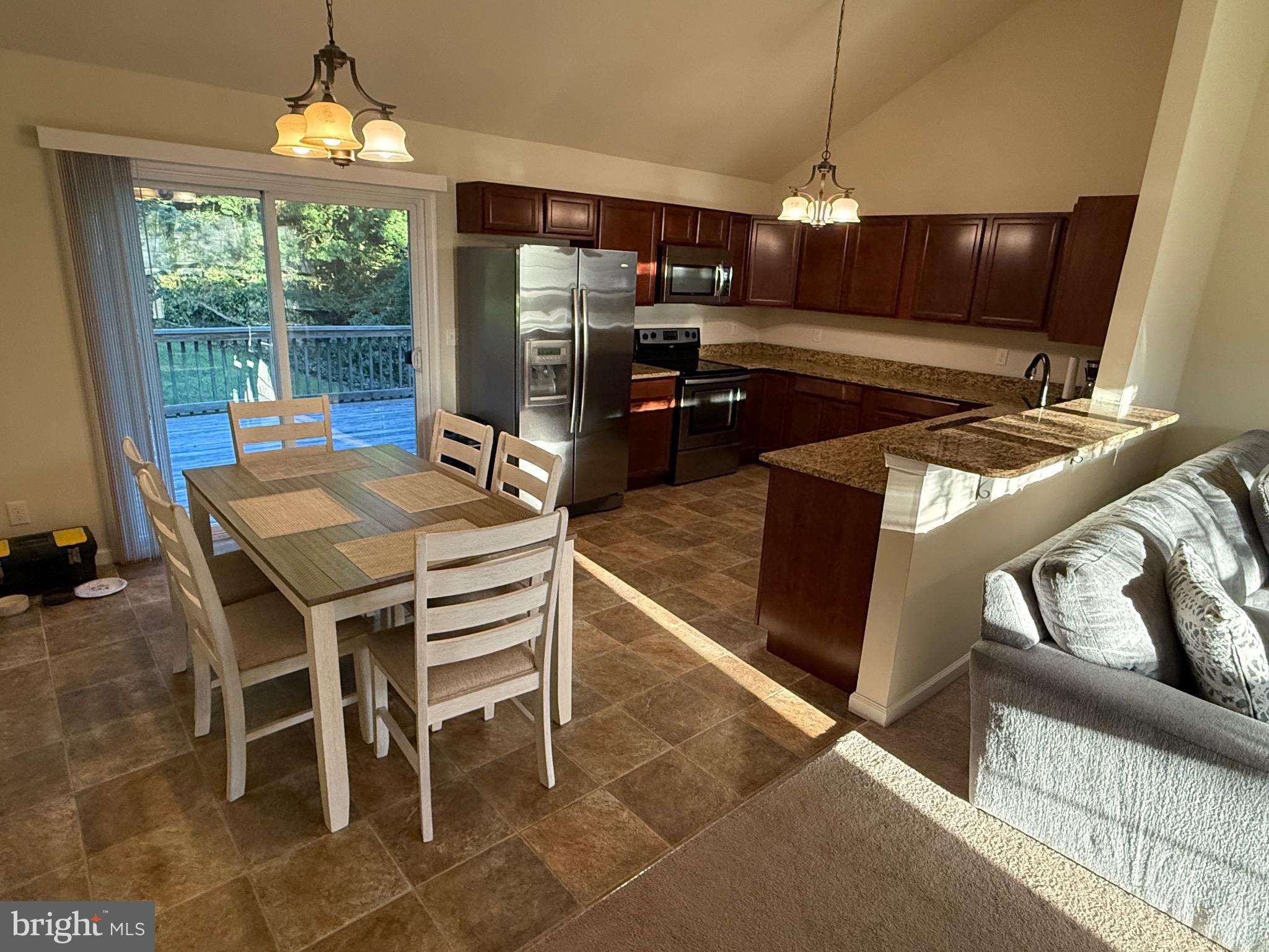 6209 Rockawalkin Road Salisbury, MD 21801 - Photo 21 of 37 a kitchen with stainless steel appliances kitchen island granite countertop a table chairs and a refrigerator