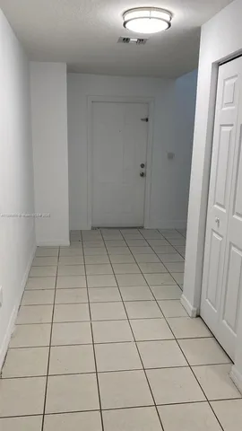 a view of a livingroom with white tiles