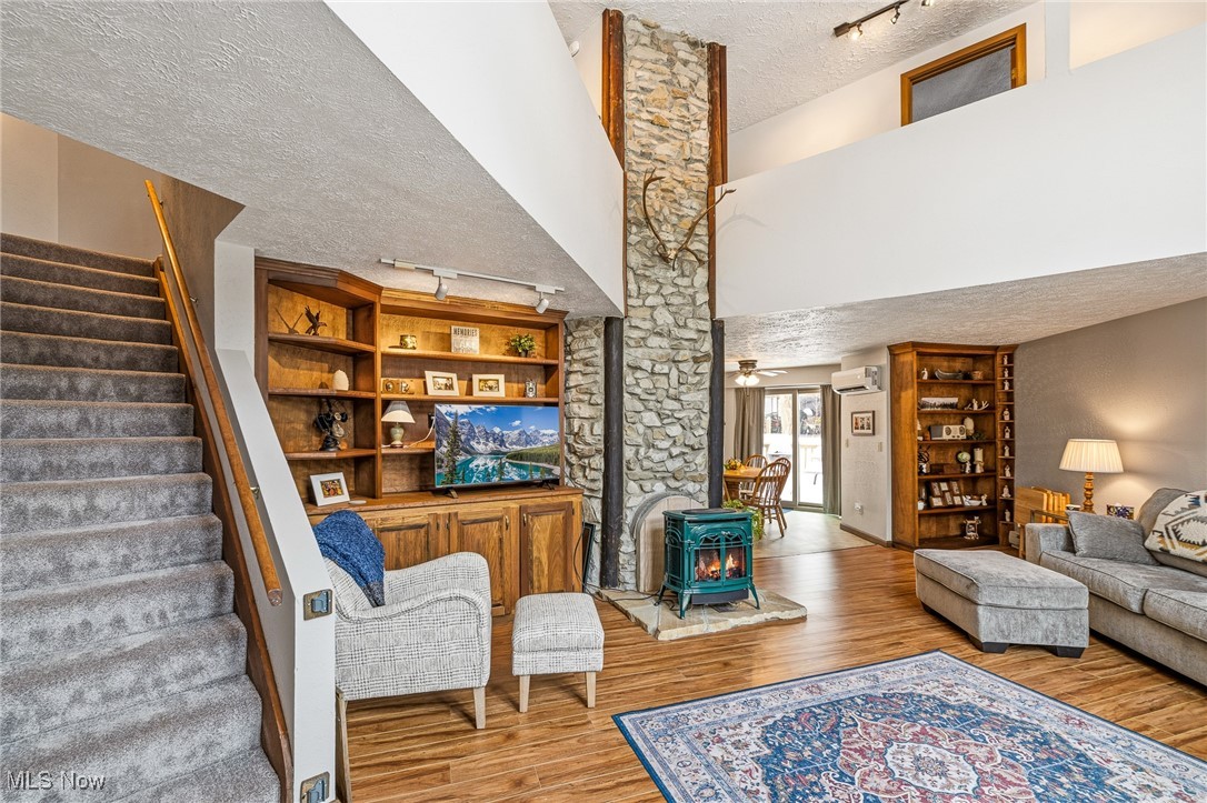 86523 North Bay Road Scio, OH 43988 - Photo 4 of 25 Living room with rail lighting, a wood stove, a textured ceiling, stairway, and a ceiling fan