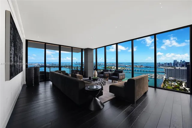 a living room with furniture and floor to ceiling windows