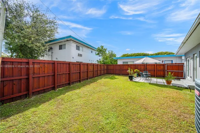 a view of an house with backyard and seating area