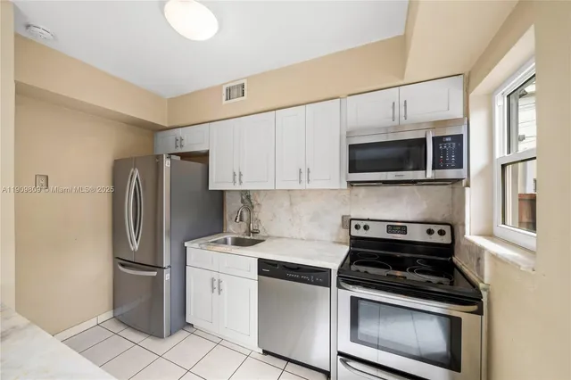 a kitchen with stainless steel appliances a refrigerator stove and microwave