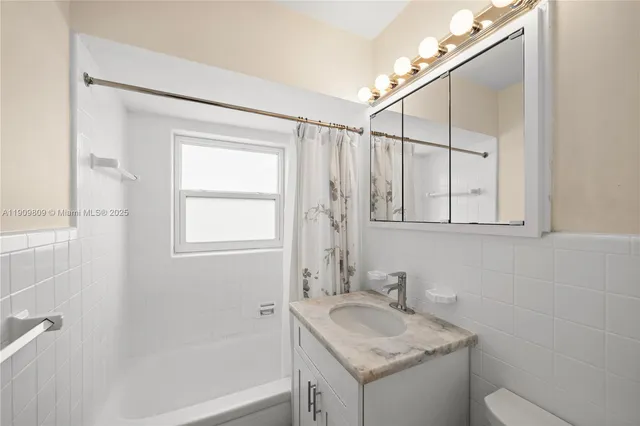 a bathroom with a granite countertop sink a toilet and shower
