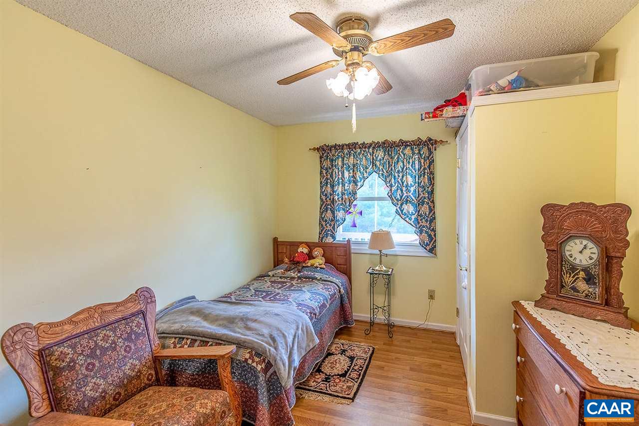 52 Morning Glory Road Ruckersville, VA 22968 - Photo 35 of 38 a bedroom with a bed and a chandelier