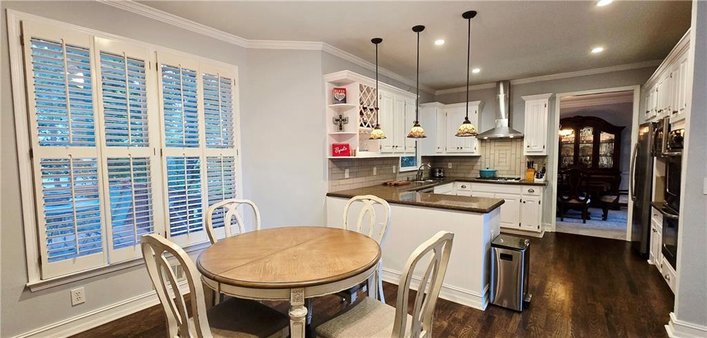 409 Misty Ridge Way Woodstock, GA 30189 - Photo 6 of 20 a kitchen with stainless steel appliances granite countertop a stove a refrigerator a kitchen island with white cabinets and wooden floor