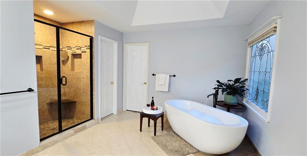 409 Misty Ridge Way Woodstock, GA 30189 - Photo 10 of 20 a bathroom with a bathtub and a shower