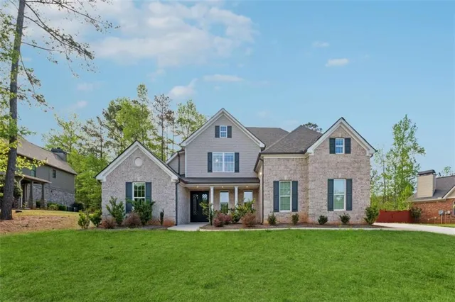 a front view of a house with a garden and yard