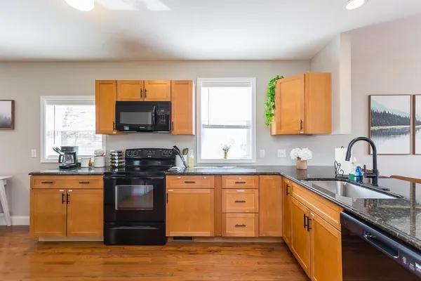 a kitchen with a sink a refrigerator a stove cabinets and living room view