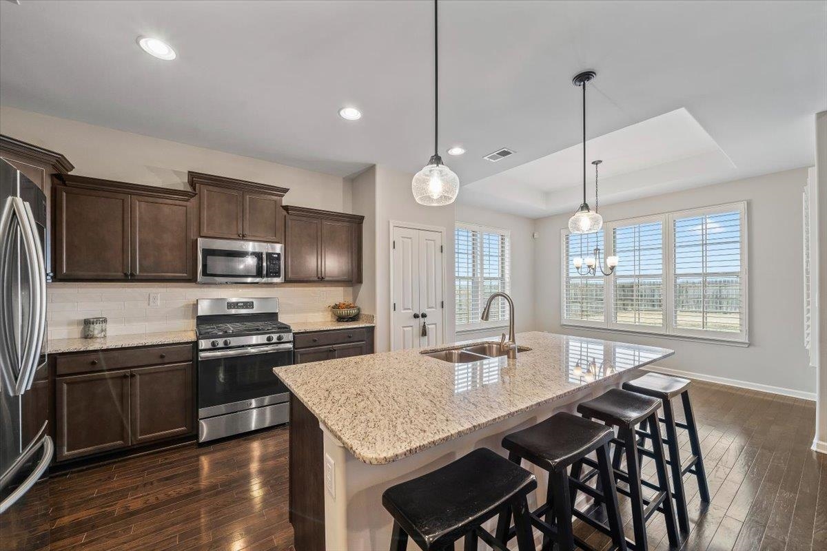 55 Cypress Point Road Oakland, TN 38060 - Photo 9 of 32 a kitchen with stainless steel appliances granite countertop a kitchen island hardwood floor sink stove dining table and chairs