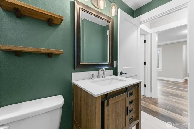 a bathroom with a sink a toilet and mirror