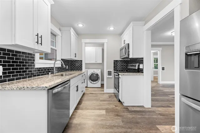 a large kitchen with granite countertop a stove top oven a sink a counter space and cabinets