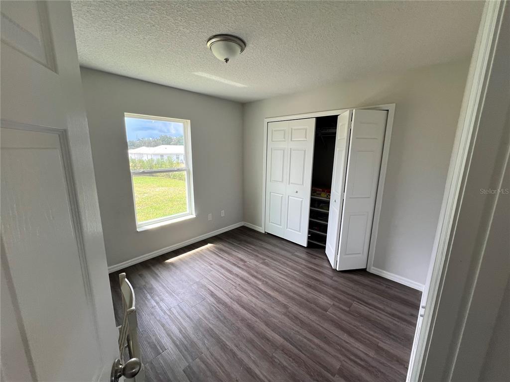 4264 East Taper Street Inverness, FL 34453 - Photo 13 of 29 an empty room with wooden floor and windows