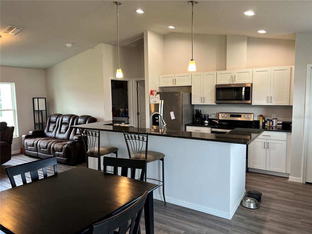 4264 East Taper Street Inverness, FL 34453 - Photo 15 of 29 a kitchen with stainless steel appliances a dining table chairs microwave and sink