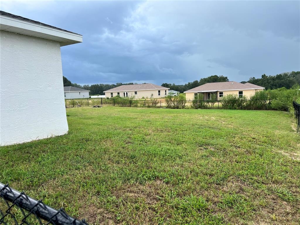 4264 East Taper Street Inverness, FL 34453 - Photo 21 of 29 a view of a big yard with an house and wooden fence