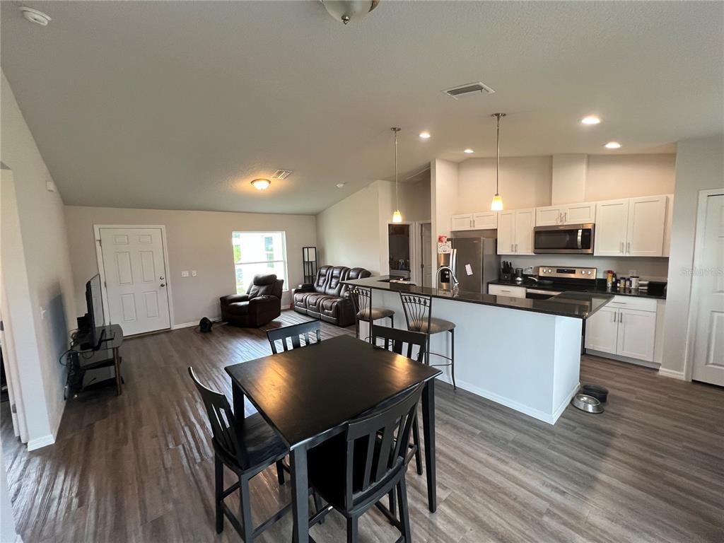 4264 East Taper Street Inverness, FL 34453 - Photo 23 of 29 a kitchen with a dining table chairs counter space and cabinets