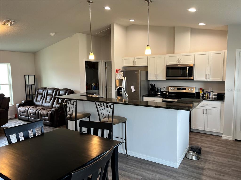 4264 East Taper Street Inverness, FL 34453 - Photo 26 of 29 a kitchen with stainless steel appliances granite countertop a stove a refrigerator a kitchen island a dining table and chairs