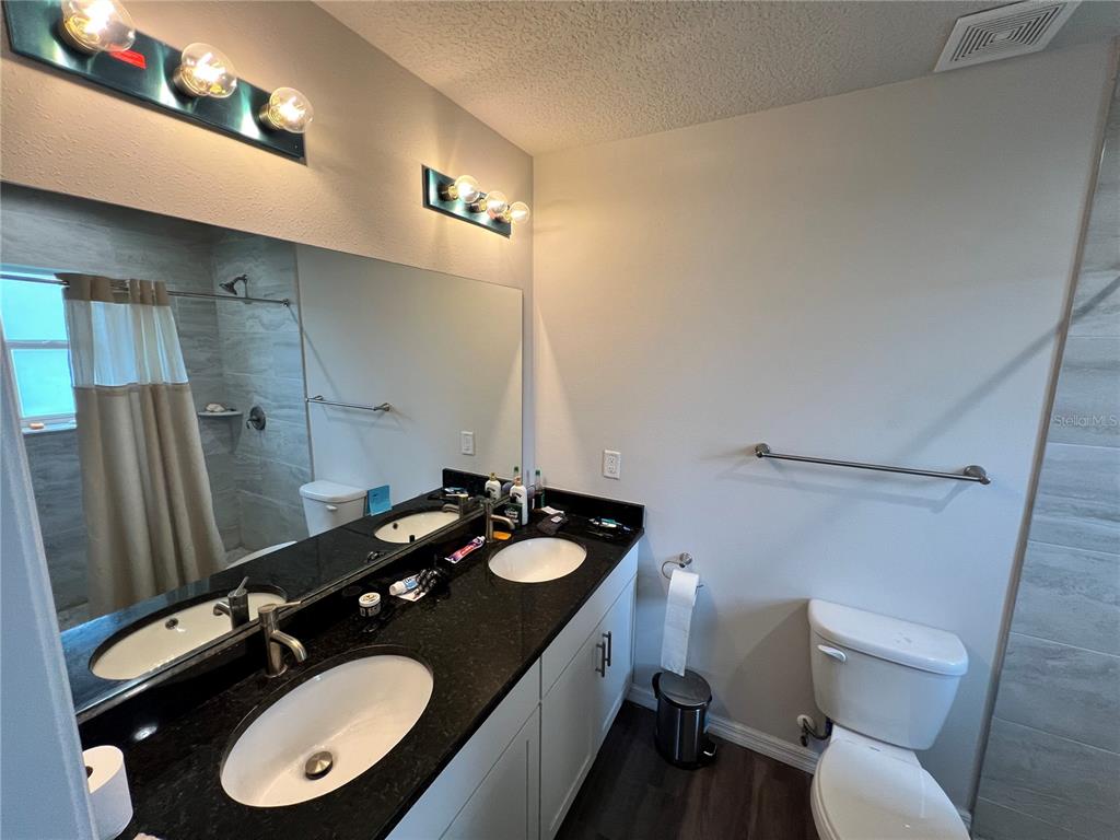 4264 East Taper Street Inverness, FL 34453 - Photo 28 of 29 a bathroom with a granite countertop sink toilet and mirror