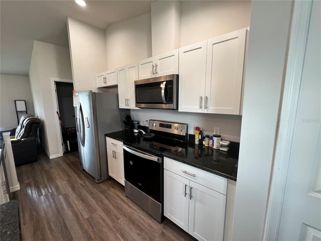 4264 East Taper Street Inverness, FL 34453 - Photo 3 of 29 a kitchen with a refrigerator stove and wooden cabinets
