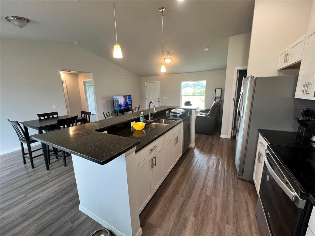 4264 East Taper Street Inverness, FL 34453 - Photo 5 of 29 a kitchen with stainless steel appliances granite countertop a sink a stove and refrigerator