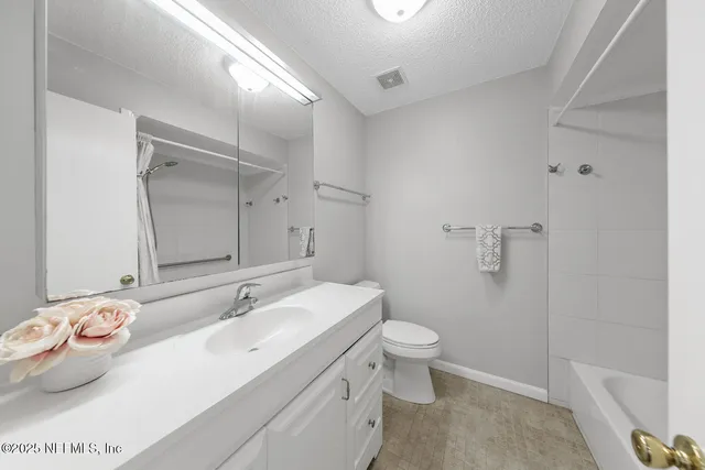 a view of a backyard with large trees and wooden fence