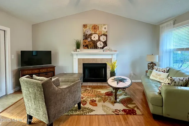 a living room with furniture a fireplace and a flat screen tv
