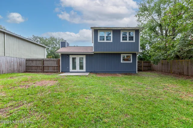 a view of a house with a potted plant ana a small yard