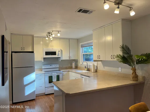 a kitchen with a refrigerator a sink and a stove