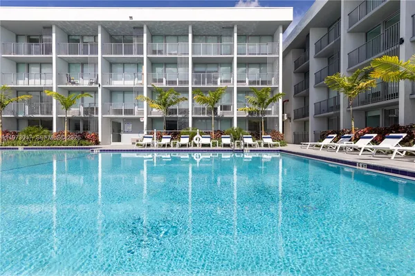 a swimming pool view with a outdoor seating space and a garden view