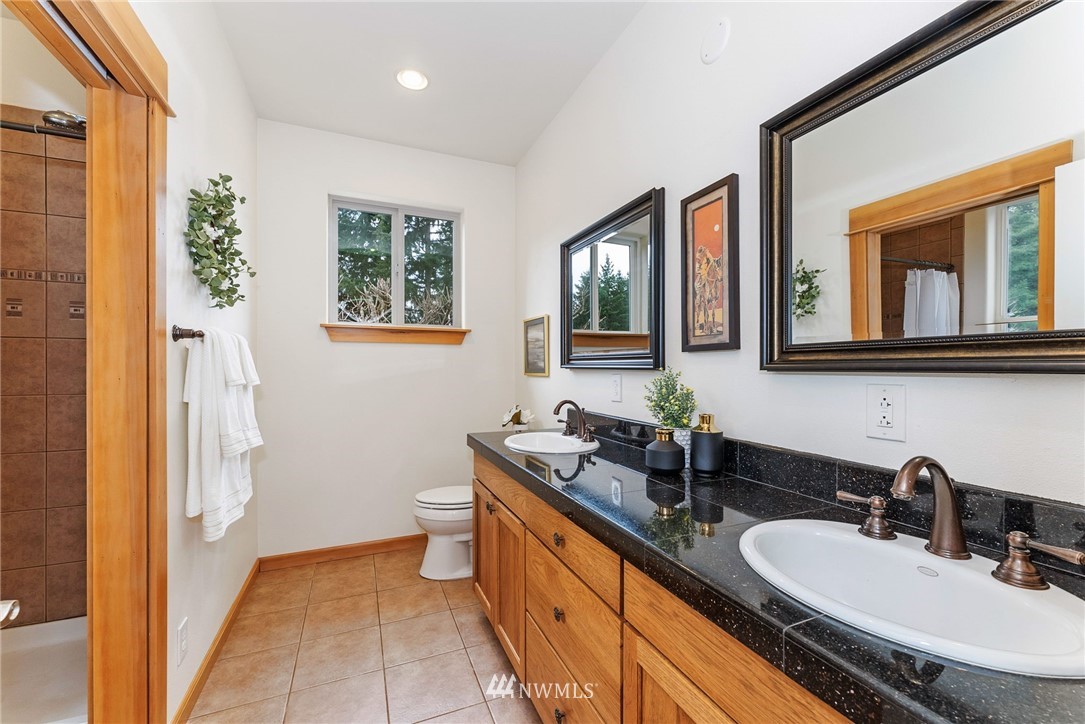 1579 Southwest J H Road Port Orchard, WA 98367 - Photo 15 of 36 a bathroom with a double vanity sink a mirror and a toilet