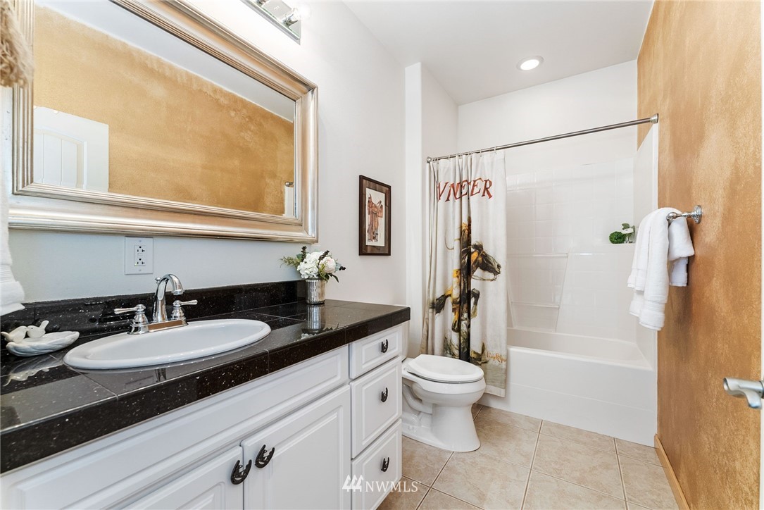 1579 Southwest J H Road Port Orchard, WA 98367 - Photo 17 of 36 a bathroom with a granite countertop sink toilet and shower