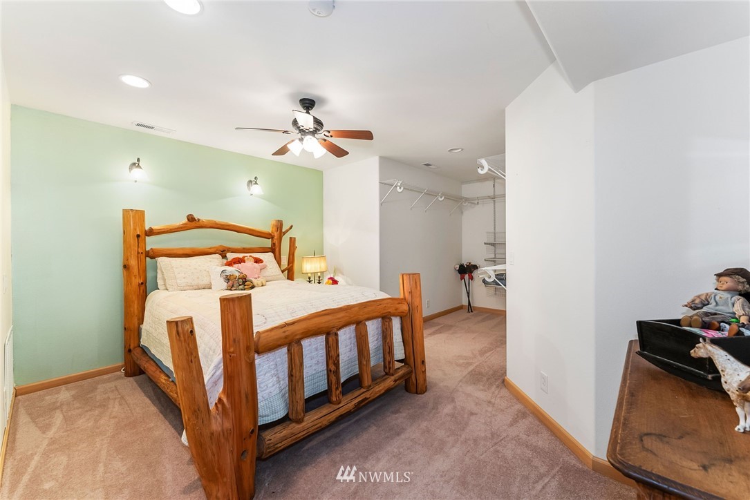 1579 Southwest J H Road Port Orchard, WA 98367 - Photo 20 of 36 a bedroom with a bed and a chandelier