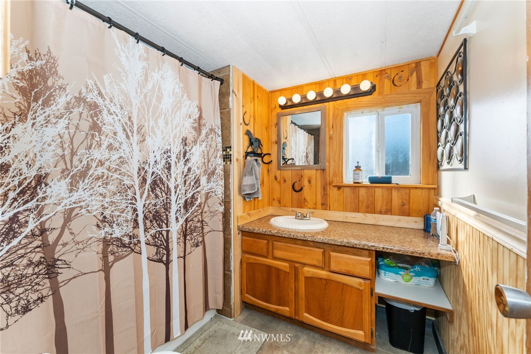 1579 Southwest J H Road Port Orchard, WA 98367 - Photo 26 of 36 a bathroom with a granite countertop sink and a mirror