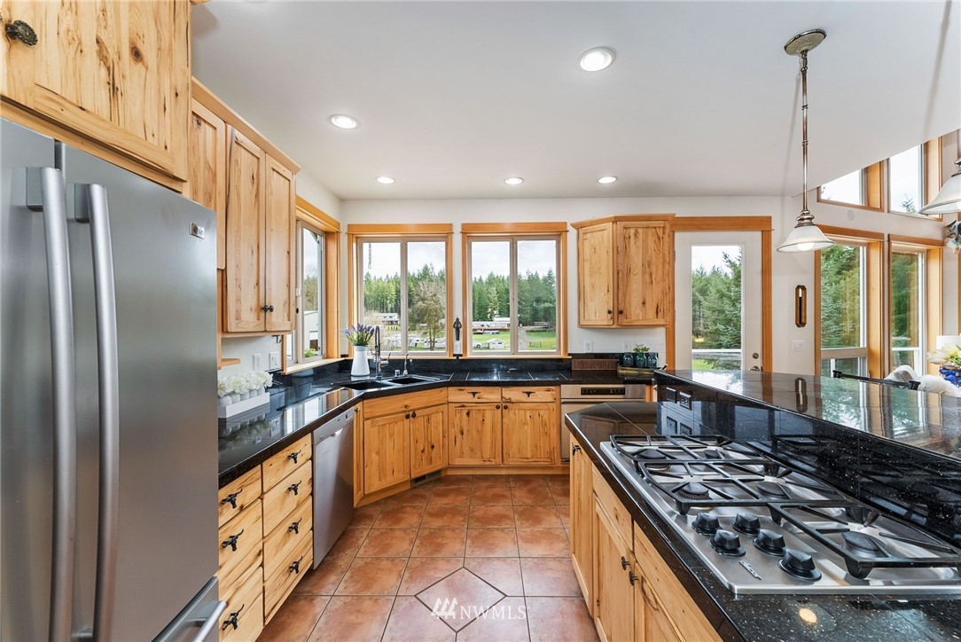 1579 Southwest J H Road Port Orchard, WA 98367 - Photo 8 of 36 a kitchen with stainless steel appliances granite countertop a stove a sink and a refrigerator