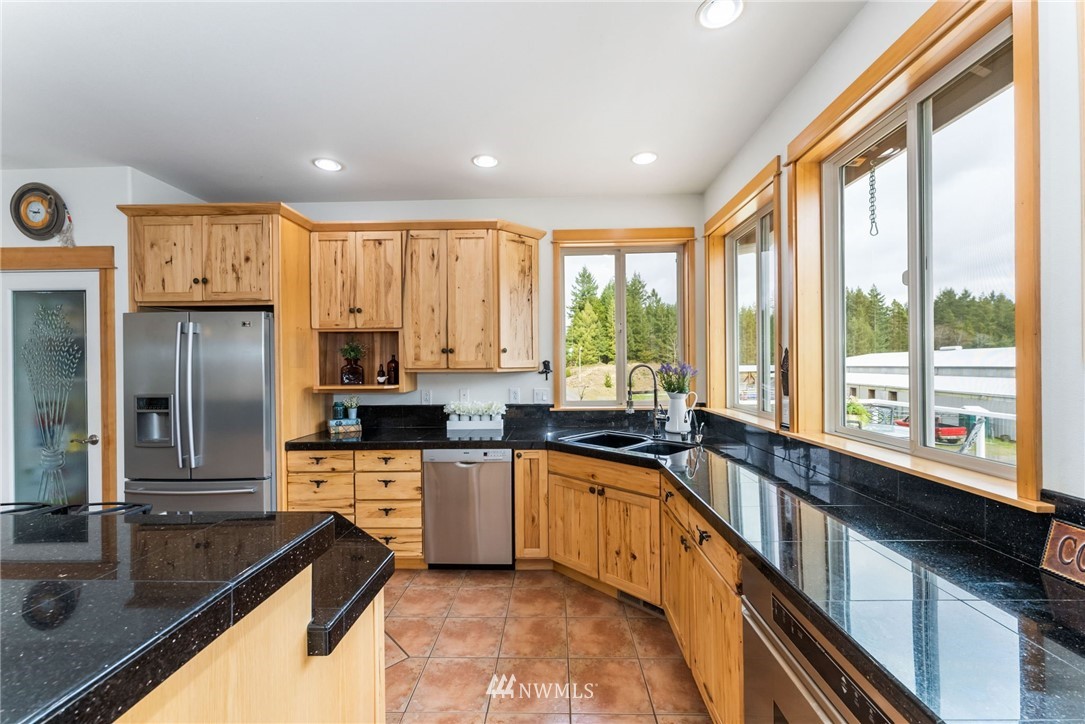 1579 Southwest J H Road Port Orchard, WA 98367 - Photo 9 of 36 a kitchen with large windows and refrigerator