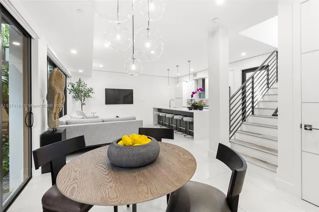 a kitchen with a sink a microwave a dining table and chairs