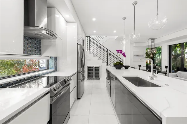 a kitchen with stainless steel appliances granite countertop a sink a stove and a wooden floors