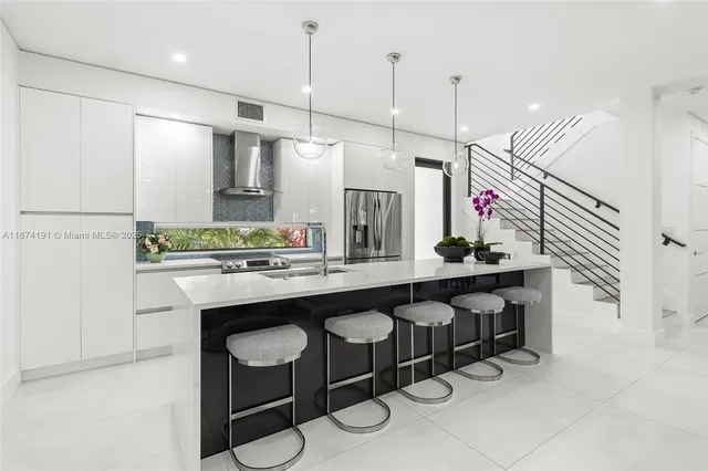 a kitchen with a sink a counter and chairs