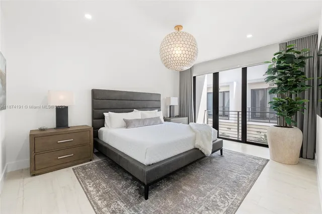 a bedroom with a large bed and a chandelier