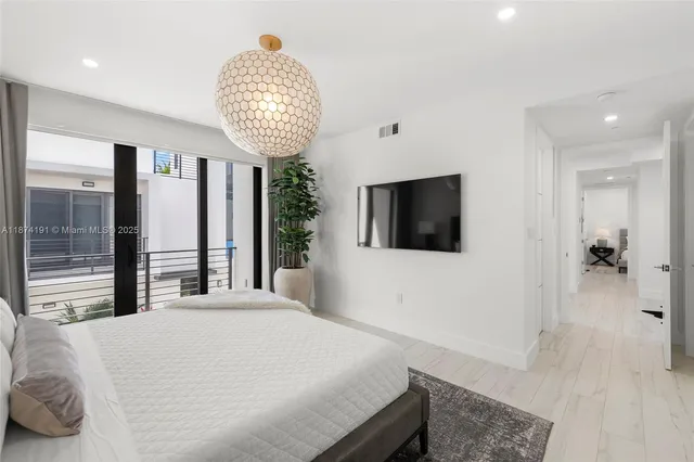 a bedroom with a bed and a chandelier