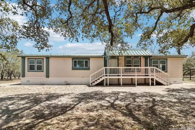 a white house that has a tree in front of it