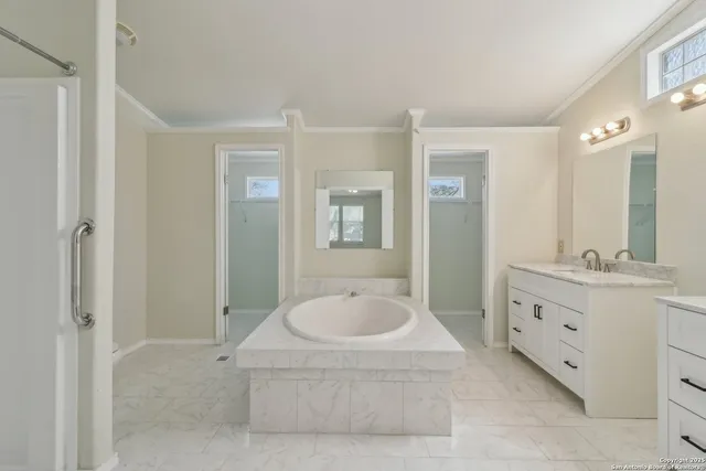 a spacious bathroom with a tub sink and mirror
