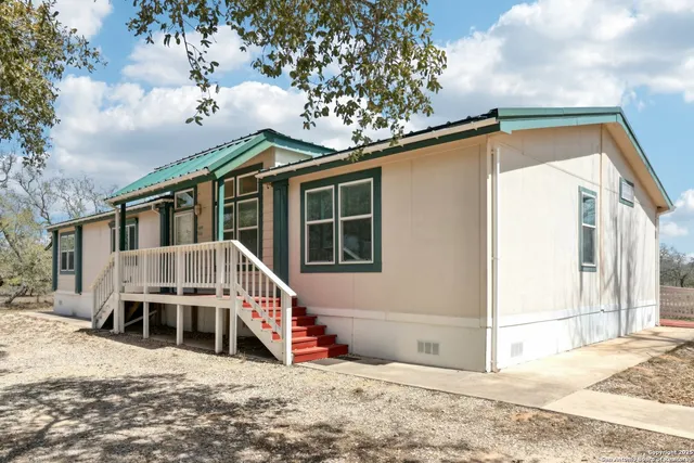 a view of a house with a small yard and wooden fence