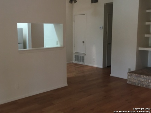 14524 Waddesdon Bluff San Antonio, TX 78233 - Photo 3 of 10 a view of an empty room with wooden floor and a cabinet