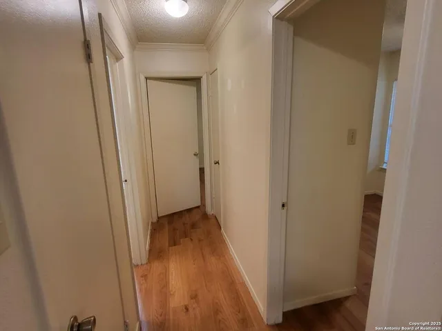 a view of a hallway with wooden floor
