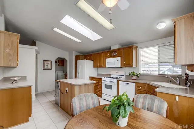 a kitchen with stainless steel appliances granite countertop a sink dishwasher stove and refrigerator with wooden floor