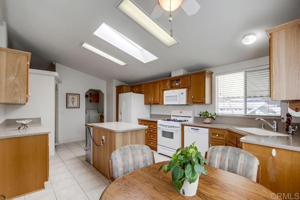 9500 Harritt Road, Unit 106 Lakeside, CA 92040 - Photo 4 of 35 a kitchen with stainless steel appliances granite countertop a sink dishwasher stove and refrigerator with wooden floor